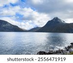 A motorhome parked by the road in the autumn landscape of Senja Island, Norway, with fjords and mountains.