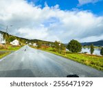 A motorhome parked by the road in the autumn landscape of Senja Island, Norway, with fjords and mountains.