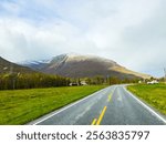 A motorhome parked by the road in the autumn landscape of Senja Island, Norway, with fjords and mountains.