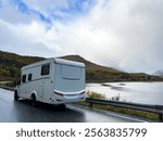 A motorhome parked by the road in the autumn landscape of Senja Island, Norway, with fjords and mountains.