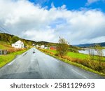 A motorhome parked by the road in the autumn landscape of Senja Island, Norway, with fjords and mountains.