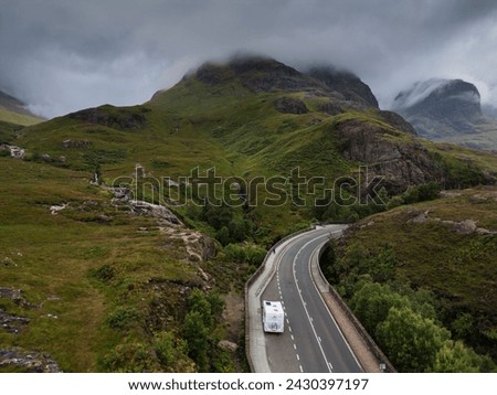 A motorhome parked on the A82 road passes The Meeting of Three Waters in Glencoe. Glencoe's Three Sisters Mountains in the background Stock photo © 