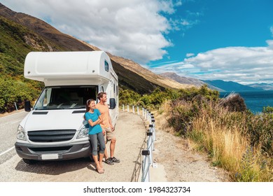 Motorhome RV camper van road trip on New Zealand. Young couple on travel vacation adventure. Two tourists looking at Lake Pukaki and mountains on enjoying view and break next to rental car - Shutterstock ID 1984323734