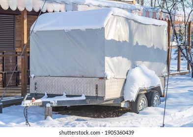 Motorhome RV, Trailer, Campervan Parked Near House Under Snow In Winter