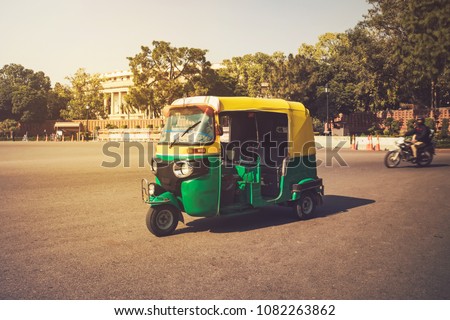 Moto-Rickshaw, New Delhi, India. Indian taxi stands on the street against backdrop of the presidential Palace. Expensive area of the city. Tricycle vintage retro motorcycle 