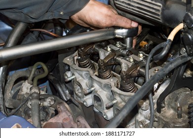 The Motorist Tightens The Bolts On The Head Of The Block Of A Three-cylinder Gasoline Internal Combustion Engine Using A Torque Wrench