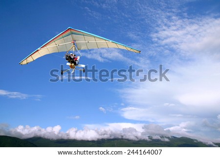 The motorized hang glider in the blue sky