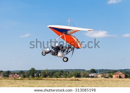 The motorized hang glider in the blue sky
