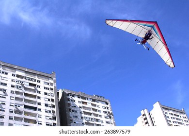 The Motorized Hang Glider Flying Over Residential Buildings In The City