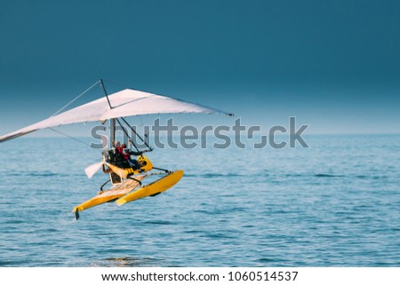 Motorized Hang Glider With Muslim Woman Take Off Frow Sea In Sunny Summer Day. Muslim People Having Fun