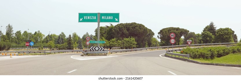motorway junction with the Italian indications for the city of VENICE on the LEFT or MILAN if you turn RIGHT without cars - Shutterstock ID 2161420607