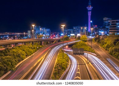 Motorway With Night Traffic In Auckland City Centre On The Horizon, New Zealand