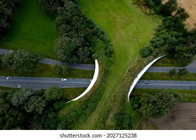 Motorway passing underneath wildlife crossing forming a safe natural corridor bridge for animals to migrate between conservancy areas. Environment nature reserve infrastructure eco passage. - Shutterstock ID 2027125238