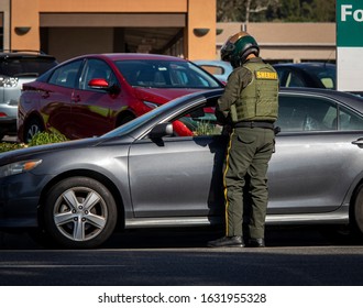 Motoycycle Police Officer Giving A Traffic Ticket To Person In Sedan Type Car