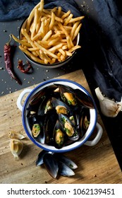 moules-frites, mussels and fries typical of Belgium, on a rustic wooden table