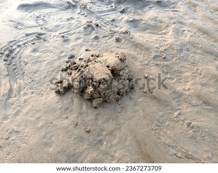 a mound of beach sand mud made by children playing