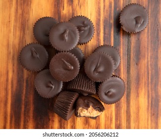 A Mound Of Chocolate Peanut Butter Cups On A Dark Wooden Table Overhead View