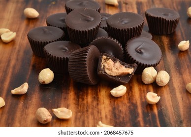 A Mound Of Chocolate Peanut Butter Cups On A Dark Wooden Table Overhead View