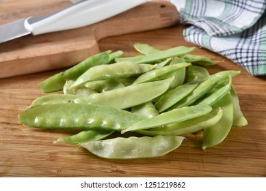 A Mound Of Fresh Snow Peas On A Cutting Board