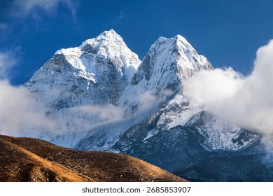 Mount Ama Dablam within cloud and blue sky evening view, way to Mt Everest base camp, Khumbu valley, Sagarmatha national park, Everest area, Nepal Himalaya mountain