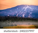 Mount Ascutney Summit and ski slopes and trails covered with snow at foggy wintry sunrise in Windsor, Vermont, USA