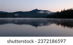Mount Chocorua overlooks Chocorua lake as dawn breaks on a summer morning in Tamworth New Hampshire.