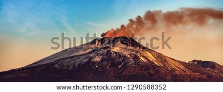 The mount Etna Volcano with smoke at dawn in winter. Catania, Sicily island, Italy, Europe