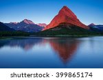 Mount Grinnell takes on a warm glow from the light of a rising sun in Montana
