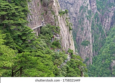 Mount Huangshan, Anhui, China - June 16, 2019: Tourists are going down the stairs on the cliff
