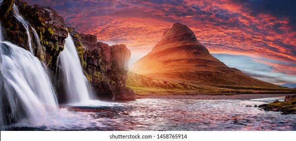 Mount Kirkjufell with dramatic sky in Iceland.Summer sunset over the famous Kirkjufellsfoss Waterfall with Kirkjufell mountain in the background in Iceland. Long exposure. Picturesque epic scenery