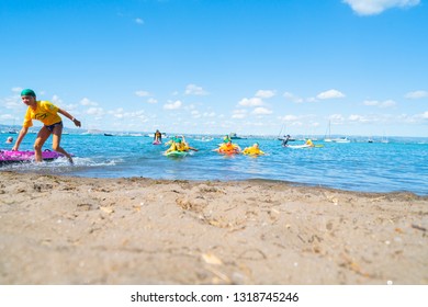 MOUNT MAUNGANUI NEW ZEALAND - FEBRUARY 10: Children Carrying Colorful Paddle Boards Developing Water Confidence Surf Lifesaving Club February 10 2019 Mount Maunganui New Zealand