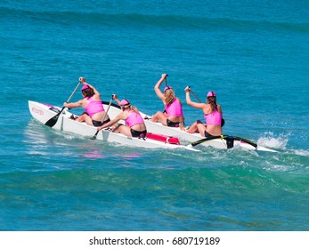 MOUNT MAUNGANUI, NEW ZEALAND - JANUARY 28; Four Women In Pink Tops Paddle Surf Outrigger Canoe In Competitions At Mount Maunganui, Surf Lifesaving, January 28, 2012, Mount Maunganui, New Zealand