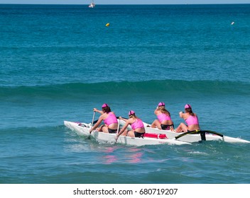 MOUNT MAUNGANUI, NEW ZEALAND - JANUARY 28; Four Women In Pink Tops Paddle Surf Outrigger Canoe Through Surf In Competitions  Surf Lifesaving, January 28, 2012, At Mount Maunganui, New Zealand