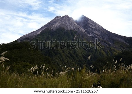 Mount Merapi, a towering active volcano in Indonesia, dominates the landscape with its smoking peak. Known for its frequent eruptions, it stands as a powerful symbol of nature's raw force.