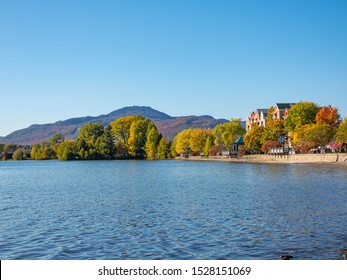 Mount Orford seen in the background on a fall day in Magog, Quebec, Canada surrounded by a forest of colorful leaves and Lake Memphremagog.