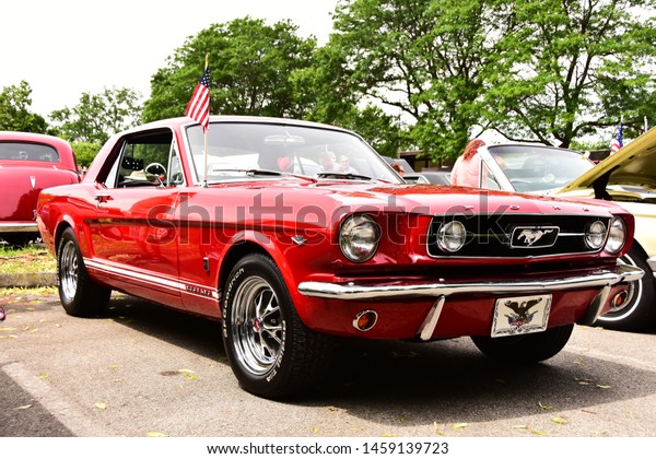 Mount Pleasant, Wisconsin / USA - July 21,\
2019: A bright red metallic 1965 Ford Mustang GT with 289 and GT\
fender badges at the Quarry Lake Car\
Show.