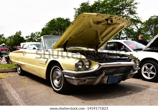Mount Pleasant, Wisconsin / USA - July 21,\
2019: A yellow 1965 Ford Thunderbird convertible shown with hood\
raised at the Quarry Lake Car\
Show.
