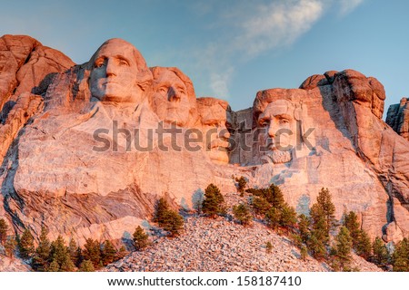 Mount Rushmore National Park in the Black Hills South Dakota during a warm sunrise with clear blue sky morning. High Dynamic Range. / Mount Rushmore National Park