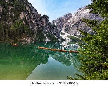 Mount Seekofel and boats in the evening light, mirroring in the clear calm water of iconic mountain lake Pragser Wildsee (Lago di Braies) in Dolomites, Unesco World Heritage, South Tyrol, Italy