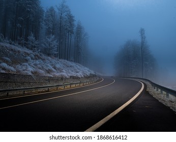 Mountain asphalt road during foggy conditions,trees covered with rime, white line. Bad weather. Jeseniky mountains,Czech Republic.