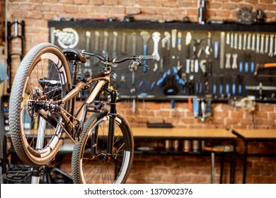 Mountain bicycle during the repairing process hanging on the stand at the workshop - Powered by Shutterstock