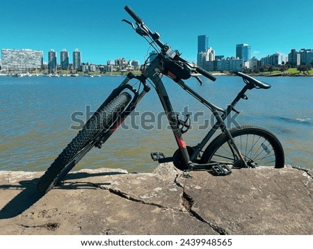 Mountain bike parked at border of breakwater with cityscape of montevideo city at background, uruguay