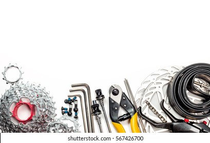 Mountain bike spares  cassette bolts chain skewers brake disk rotors levers tube sprockets and tools allen keys cable cutter on white background