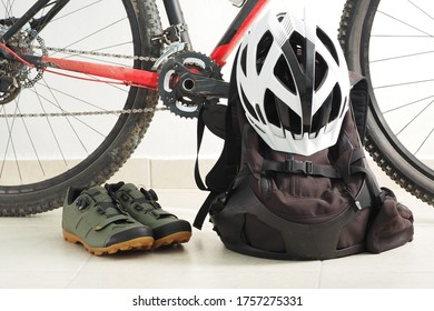 Mountain Bike, Velo Shoes, Backpack And White Helmet At Home.