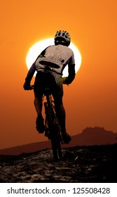 Mountain Biker Agonizes Uphill During Sunset