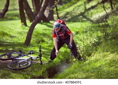 Mountain biker drinking water from a spring