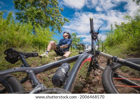 A mountain biker has an accident, falls and injures his legs and knees. MTB, Mountain bike athlete Accident, falls, leg and knee injuries. Concept accident from extreme sports and MTB, mountain bike.