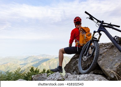 Mountain biker looking at view on bike trail in autumn mountains. Male rider resting on cycling trip in nature. Sport fitness, motivation and inspiration in beautiful inspirational landscape. - Powered by Shutterstock