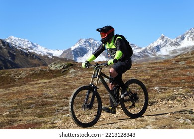 A Mountain Biker On The Summit In The Snowy Alps