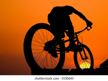 Mountain Biker Silhouette On Sea Sunset Background